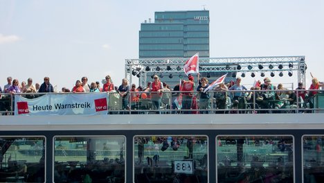 Das Foto zeigt Beschäftigte des Öffentlichen Dientes bei einem Warnstreik auf einem Boot auf dem Rehin bei Düsseldorf.